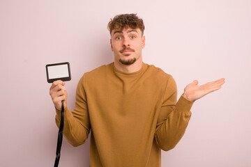 young cool man feeling puzzled and confused and doubting. vip pass id concept
