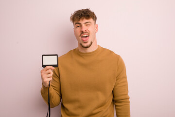 young cool man with cheerful and rebellious attitude, joking and sticking tongue out. vip pass id...