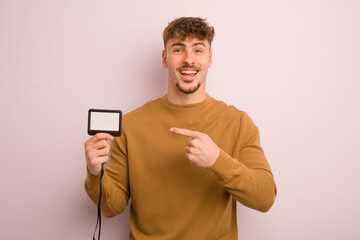 young cool man looking excited and surprised pointing to the side. vip pass id concept