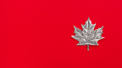 Silver Canadian maple leaf on red with copy space