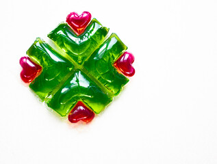 Washing capsules on a white background. Liquid laundry detergent in red-green heart-shaped capsules.