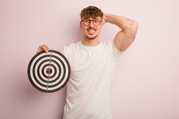 young cool man feeling stressed, anxious or scared, with hands on head. dart target concept