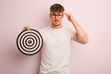 young cool man feeling confused and puzzled, showing you are insane. dart target concept