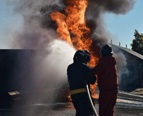 Obraz premium Firefighter extinguishing a traffic accident fire