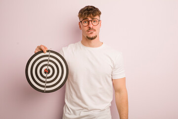 young cool man looking puzzled and confused. dart target concept