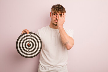 young cool man feeling bored, frustrated and sleepy after a tiresome. dart target concept