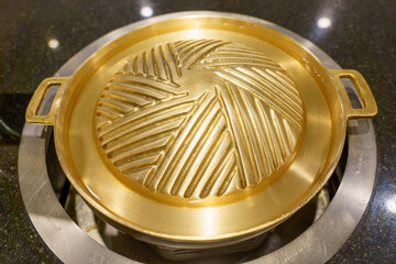 Brass grill pan placed on the gas stove