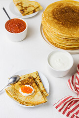 Pancakes with sour cream and caviar on a white background. Maslenitsa.