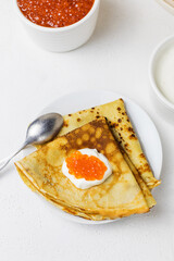 Pancakes with sour cream and caviar on a white background. Maslenitsa.Closeup