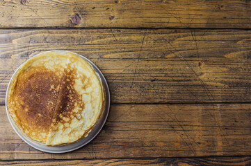 Obraz na płótnie Canvas high stack of pancakes on a wooden background. Maslenitsa