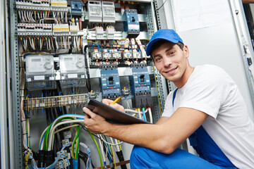 electrician worker inspecting equipment and electricity meter - obrazy, fototapety, plakaty