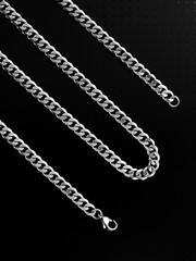Men's silver chain on a black background with standard links