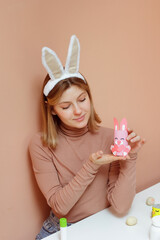 Beautiful young woman with bunny ears making Handmade Easter decoration little rabbit DIY. Reuse concept art from roll.