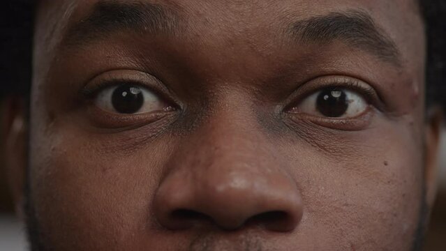 Extreme close-up of a surprised african-american man's eyes recieving good news