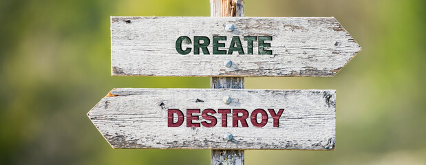 opposite signs on wooden signpost with the text quote create destroy engraved. Web banner format.