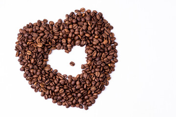 heart of brown fragrant coffee beans lie on a white background for text