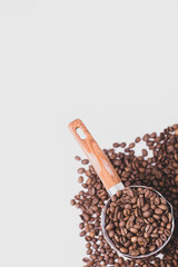 fragrant beans from the coffee tree in medium roast lie on a white background with space for text in an iron coffee maker with a brown handle