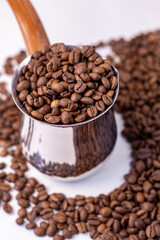 fragrant coffee beans stand on a white background in an iron coffee maker
