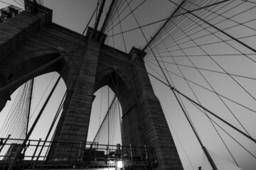 Naklejka premium Beautiful black and white bridge photo in NYC, looking up at bridge wires