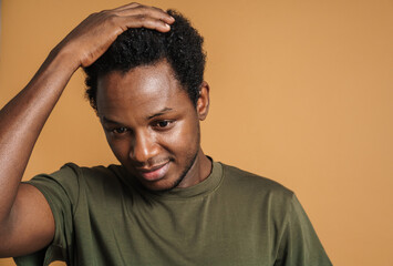 Young black man holding his head and looking downward