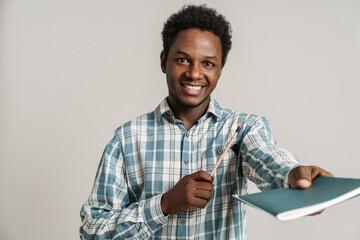Black unshaven man in plaid shirt posing with exercise book