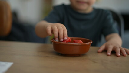 Little boy grabbing food from bowl