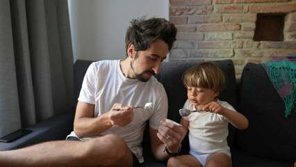 Father and son eating yogurt together dad and boy bonding real life