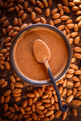 Overhead view of freshly made almond butter with whole raw almonds on the surface