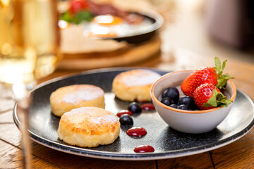 cheesecakes with berries on a plate garnished with jam. healthy breakfast.