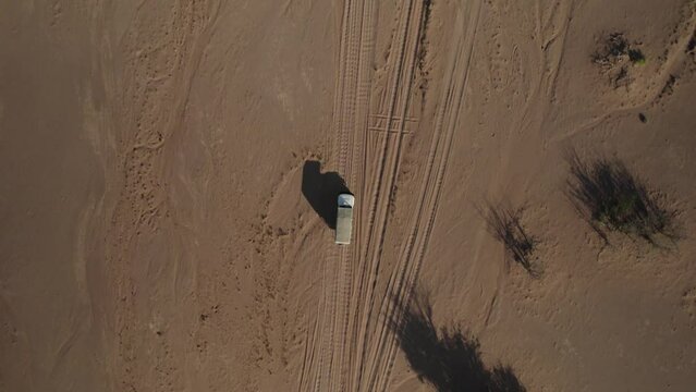 4x4 truck driving on sandy track in the arid desert; top down aerial