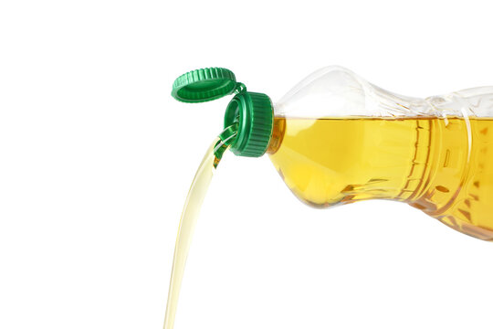Pouring cooking oil from plastic bottle isolated on white background.