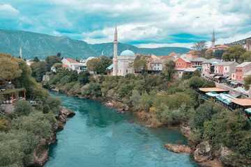 Fototapeta na wymiar The view of Mostar’s Koski Mehmed Pasha Mosque from the old bridge showing the mosque