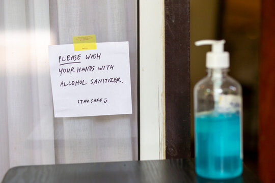 Warning signs written on white paper in front of restaurants, coffee shops, wash your hands with alcohol gel before entering the shop. during the covid epidemic