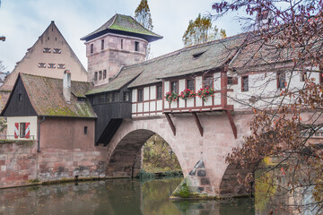Fototapeta na wymiar Nuremberg landmark. Medieval houses and bridge over canal with autumn trees. Old town of Nuremberg, Germany. Tranquil autumn landscape in old town. Fall season in historical downtown.