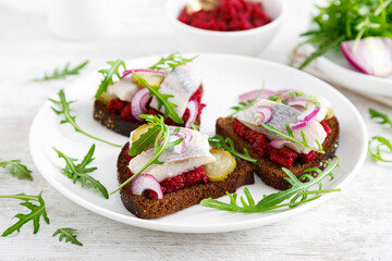 Sandwiches with salted herring fillet and beetroot pate
