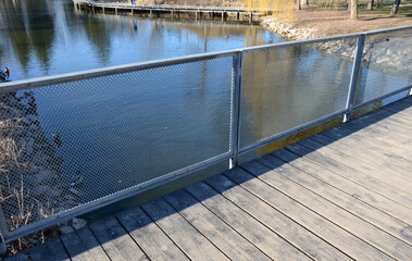 metal galvanized railing on the bridge. The filling is formed by a metal mesh of expanded metal....