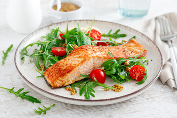 Salmon fish fillet grilled and fresh vegetable tomato salad with arugula. Healthy food. Ketogenic...