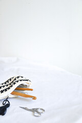 crochet needles in hand knitting bag and stork scissors on white background