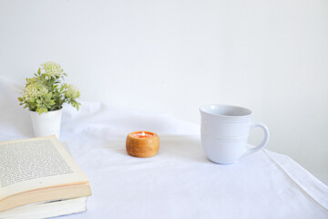 reading moment with candle, cup of tea and flowers