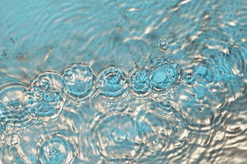 Cosmetic moisturizer micellar water. Gold powder particles forms on water surface. Abstract liquid wavy background