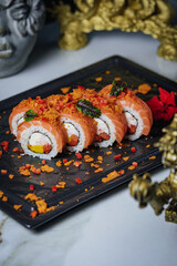 sushi on a black board lies on a marble tile