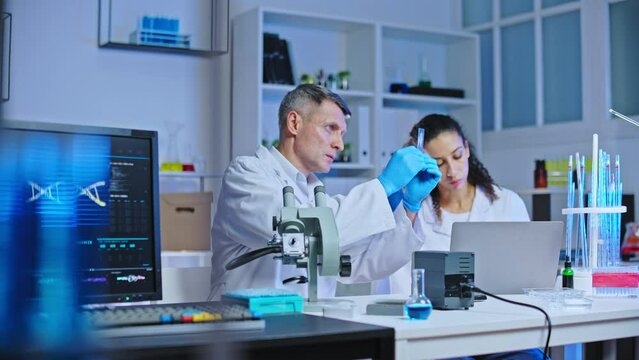 Professor and student examining and discussing medical sample in lab, education