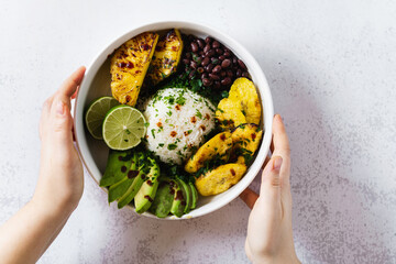 vegan poke bowl with latin american, caribbean ingredients : rice, black beans, avocado, fried...
