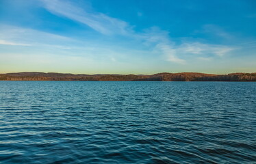Autumn landscape with lake, trees, mountains and sky with clouds