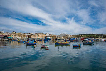 Fototapeta na wymiar Traditional colorful fishing boats in the harbor of fishing village Marsaxlokk, Malta