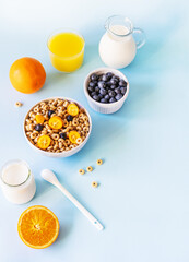 Healthy breakfast concept with wholegrain hoops, milk, orange juice, yogurt and blueberries