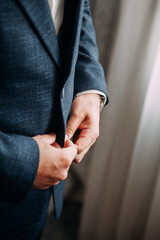 Mens hands fasten the buttons of a jacket 3827.