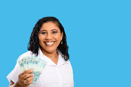 woman smiling holding brazilian money bills, positively surprised, space for text, person, advertising concept