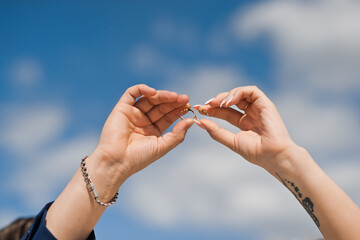 The hands of the newlyweds with wedding rings on the background of th