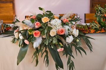 The central decoration on the wedding table is in the form of a large bou